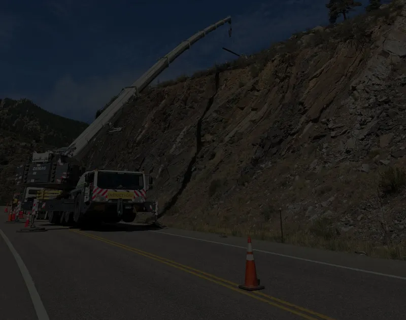 Kran crane working along a mountain highway rock cut